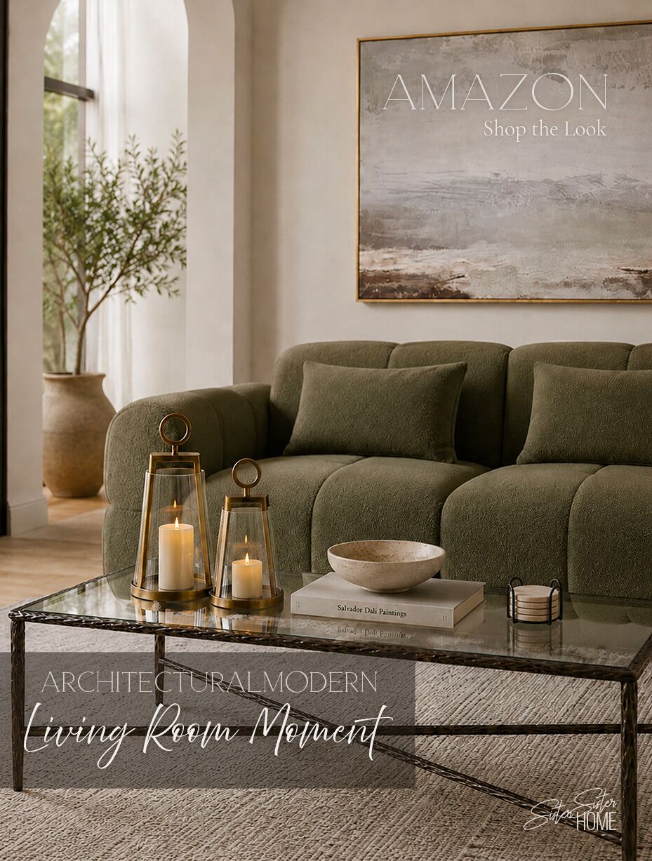 Architectural modern living room with an olive green sofa, glass coffee table, brass lanterns, travertine bowl, and neutral textured rug